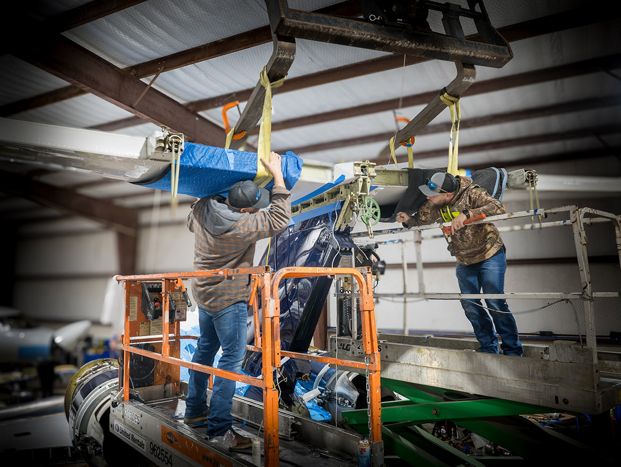 Technician performing aircraft tail section maintenance