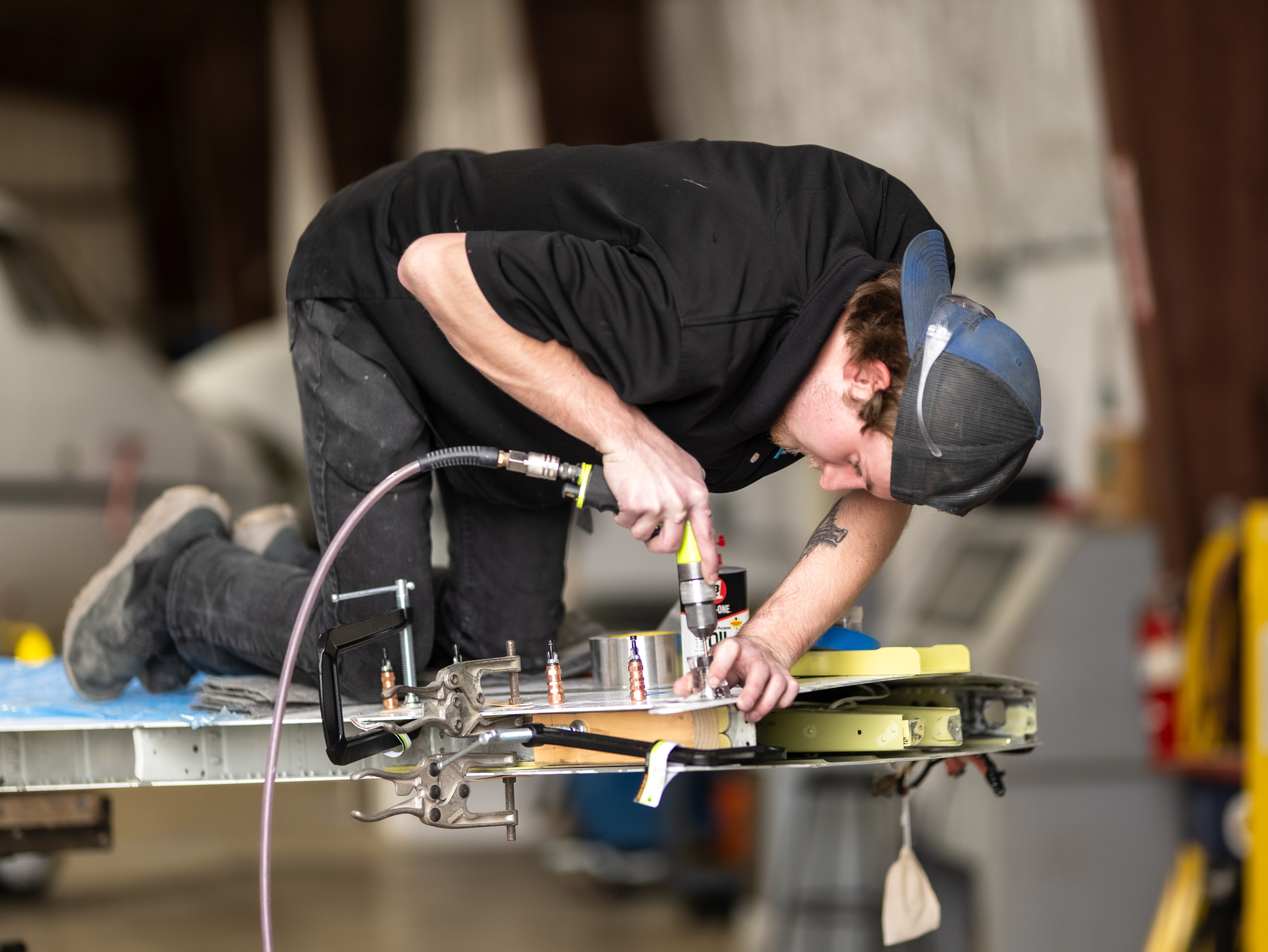 PPA technician drilling winglet components on workbench